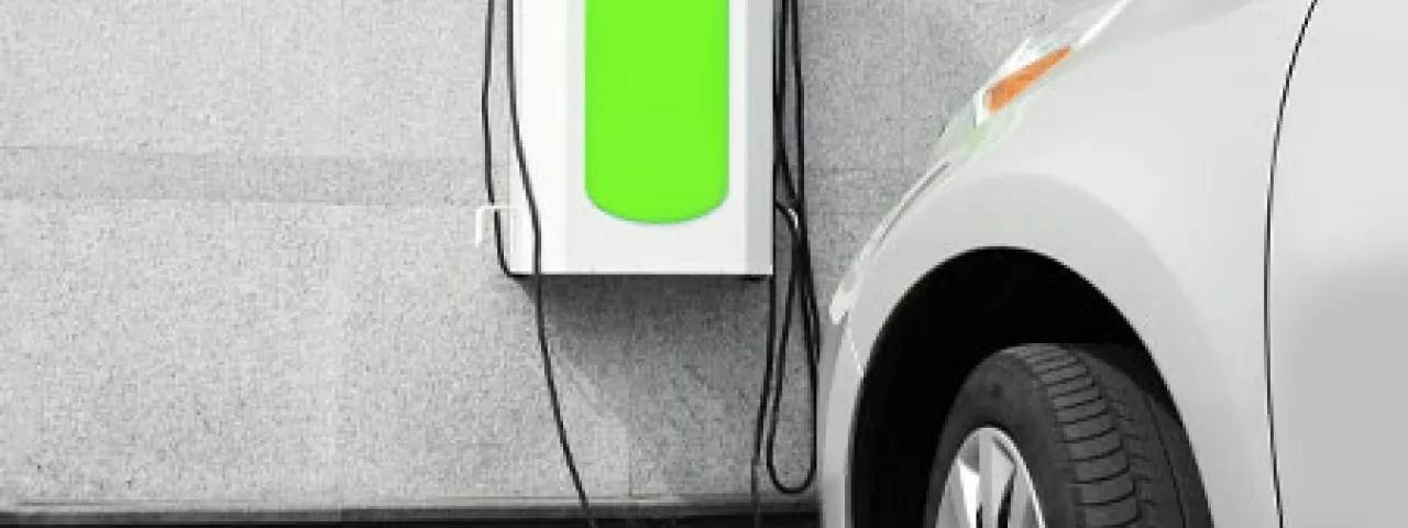 Vehículo estacionado junto a un punto de recarga