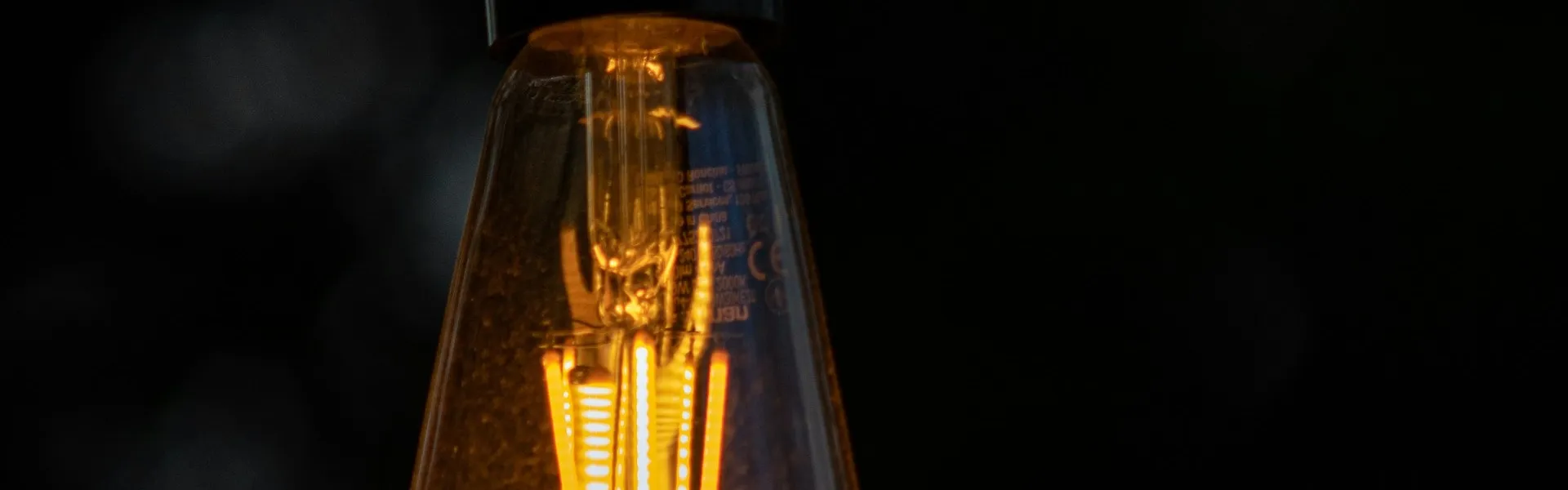 Bombilla cálida encendida sobre un fondo oscuro